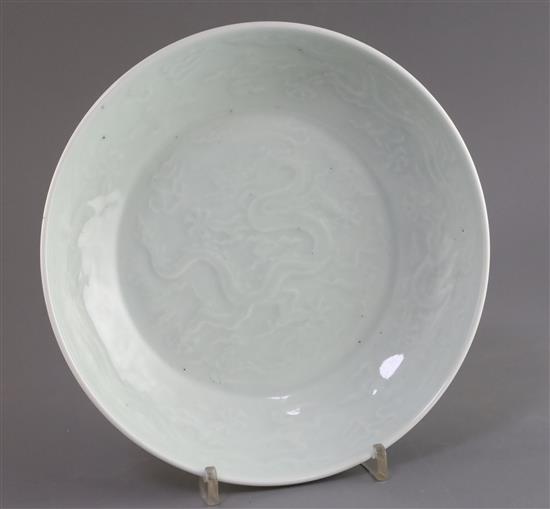 A Chinese pale celadon glazed dragon dish, D. 24.7cm